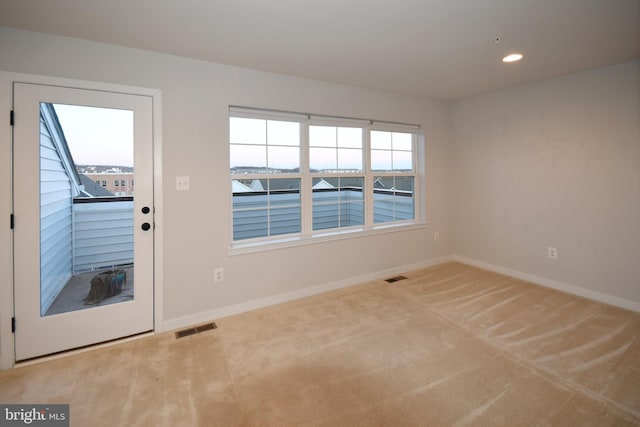 doorway featuring carpet floors, visible vents, and baseboards