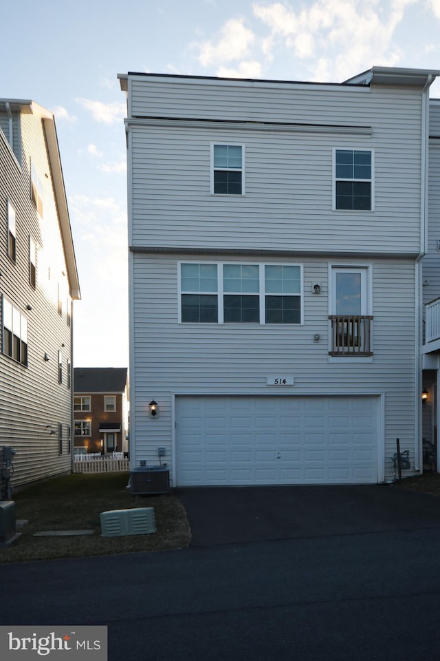 view of front of property with aphalt driveway and central AC