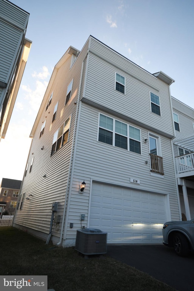 back of property with a garage and central air condition unit