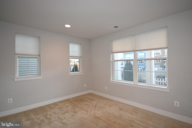 carpeted spare room with visible vents, baseboards, and recessed lighting