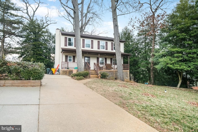 view of front of home featuring covered porch, driveway, a front lawn, and a chimney