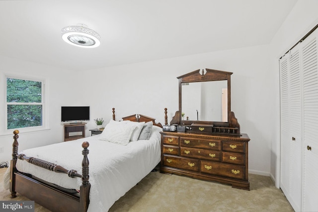 bedroom with light carpet and a closet