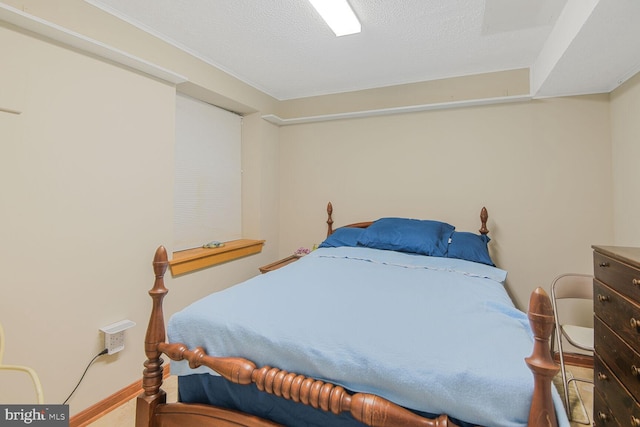 bedroom featuring a textured ceiling and baseboards