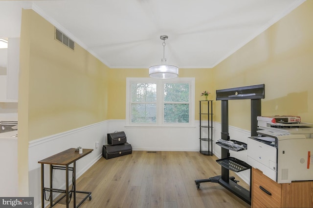 workout room featuring a wainscoted wall, ornamental molding, visible vents, and hardwood / wood-style floors