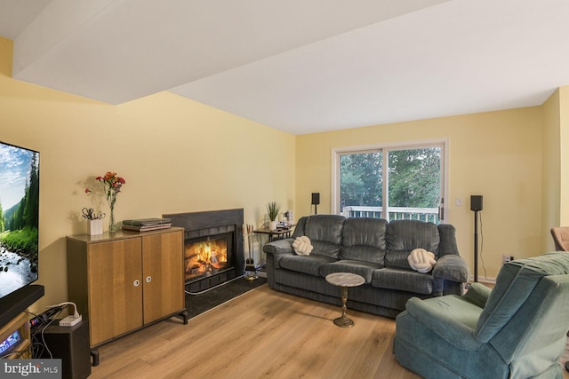 living area with a fireplace with flush hearth and light wood-type flooring