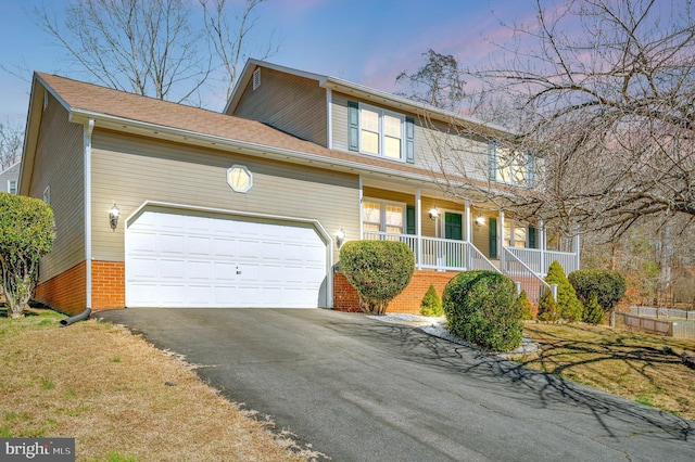 view of front of property with covered porch, brick siding, driveway, and an attached garage