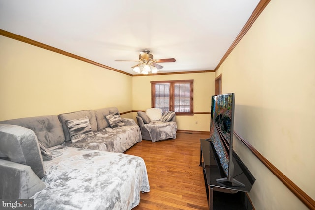 living room with ceiling fan, baseboards, wood finished floors, and crown molding