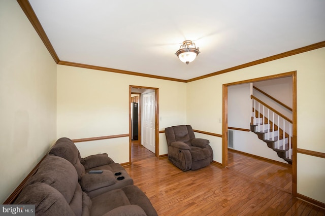 living room featuring ornamental molding, wood finished floors, and baseboards