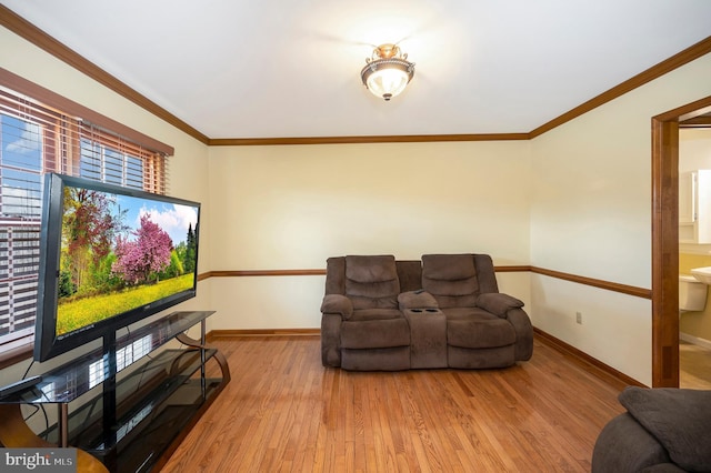 living area with ornamental molding, wood finished floors, and baseboards