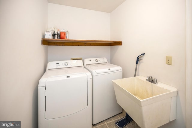 washroom featuring laundry area, a sink, and washer and dryer