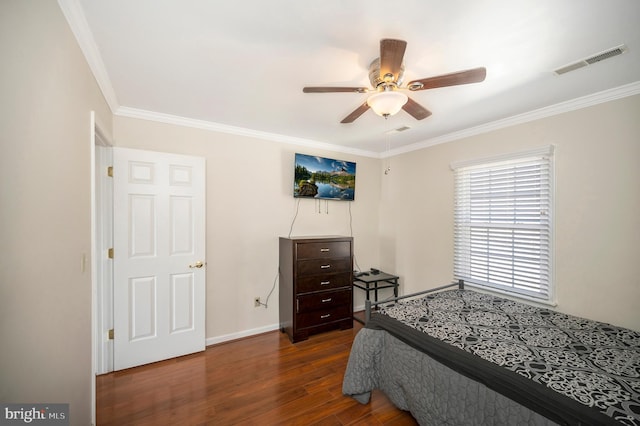 bedroom with wood finished floors, a ceiling fan, baseboards, visible vents, and crown molding