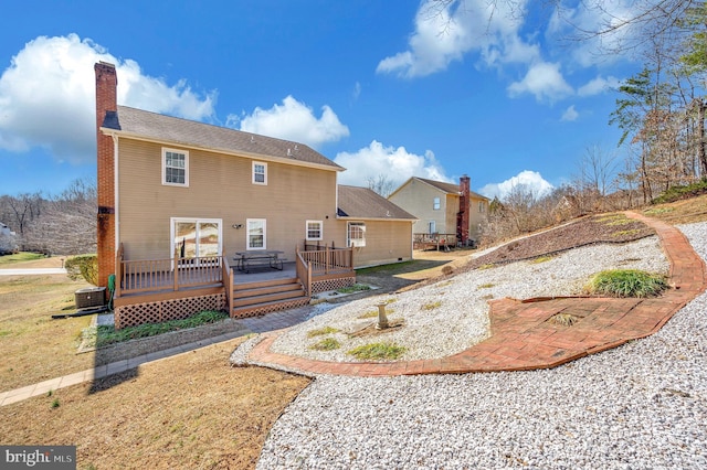 back of property with a patio, a chimney, and a wooden deck