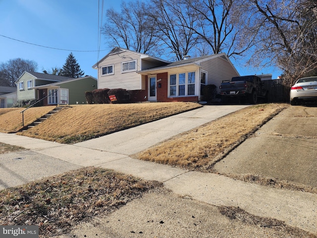 split level home featuring concrete driveway and brick siding