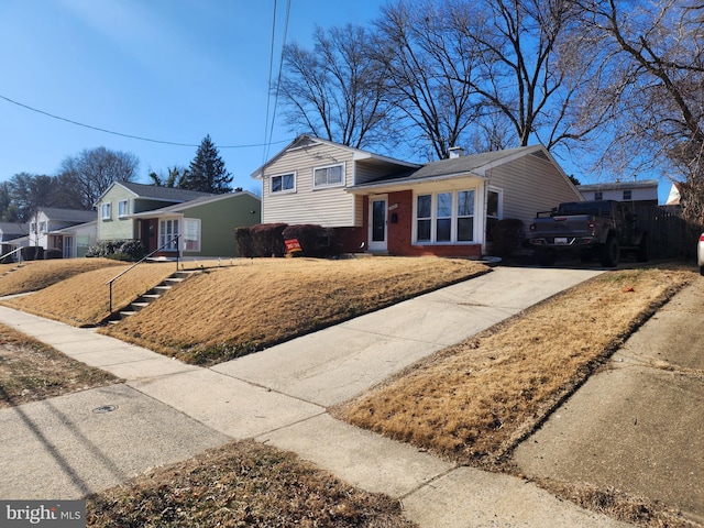 split level home featuring brick siding and driveway