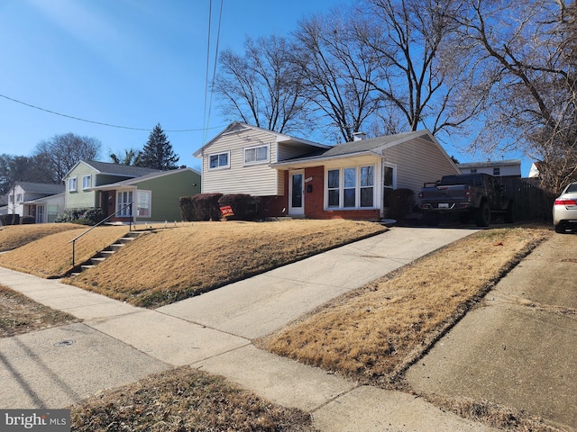 split level home featuring driveway and brick siding