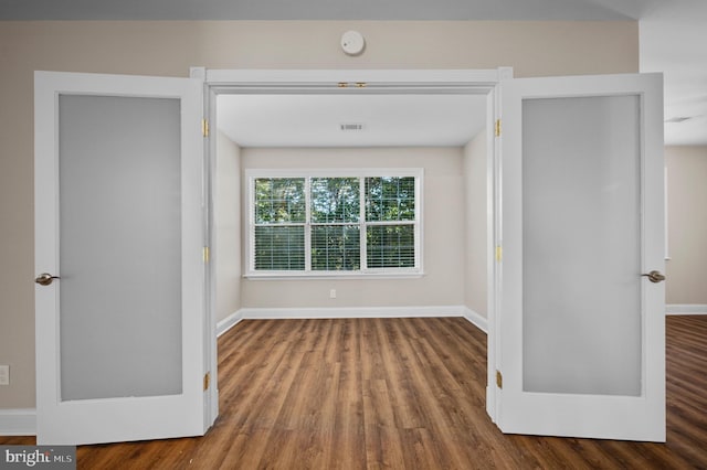 unfurnished bedroom featuring visible vents, baseboards, and wood finished floors