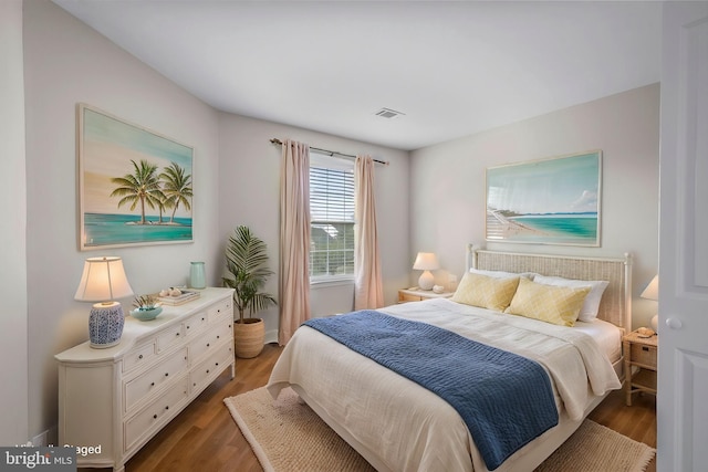 bedroom with visible vents and wood finished floors