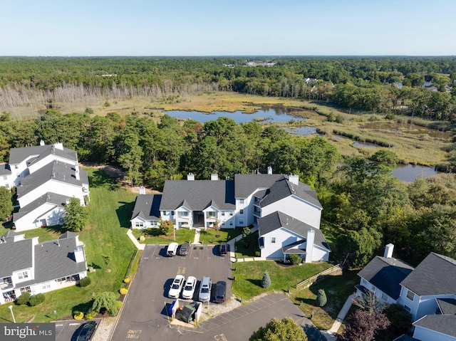 aerial view featuring a forest view, a water view, and a residential view