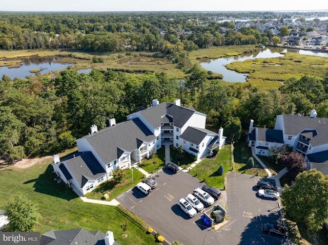 bird's eye view featuring a forest view, a water view, and a residential view