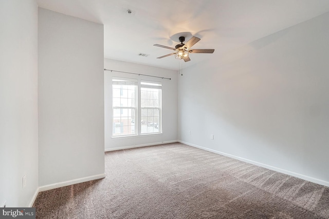 spare room featuring ceiling fan, carpet, visible vents, and baseboards