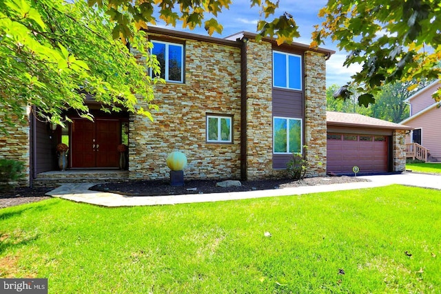 view of front of house featuring a garage, driveway, and a front yard