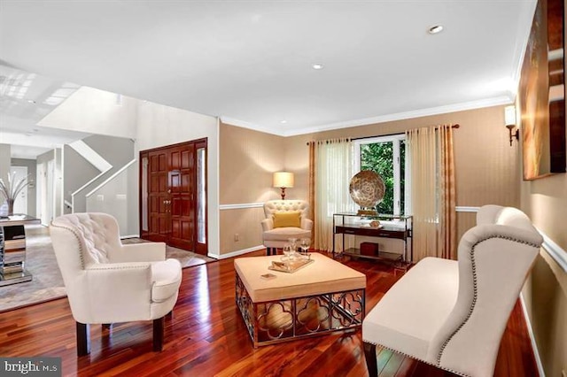 sitting room with baseboards, wood finished floors, and crown molding