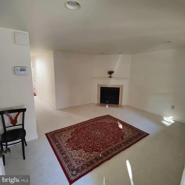 unfurnished living room with a fireplace with flush hearth and carpet flooring