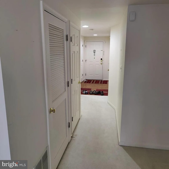 hallway with recessed lighting, baseboards, and light carpet