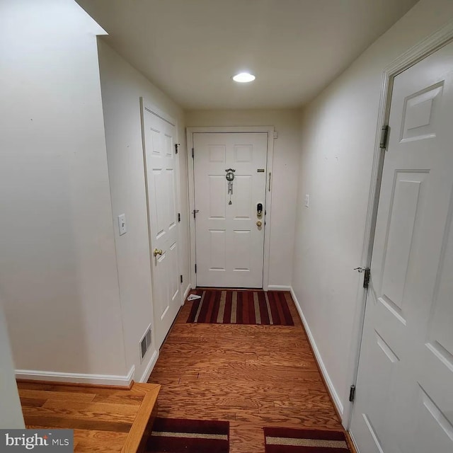 entryway with wood finished floors, baseboards, and recessed lighting
