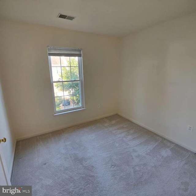spare room featuring carpet flooring and baseboards