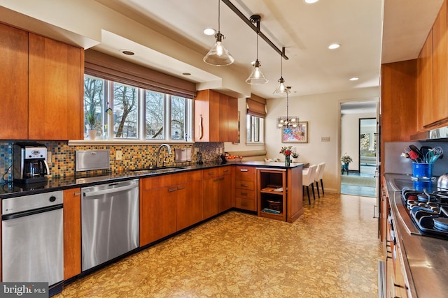 kitchen featuring tasteful backsplash, dark countertops, brown cabinets, stainless steel dishwasher, and a sink