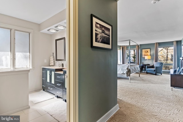 hallway featuring a sink and baseboards