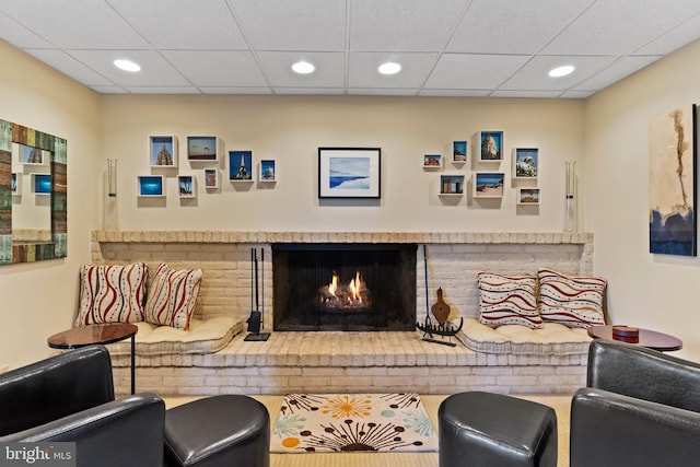 interior space featuring recessed lighting, a brick fireplace, and a drop ceiling