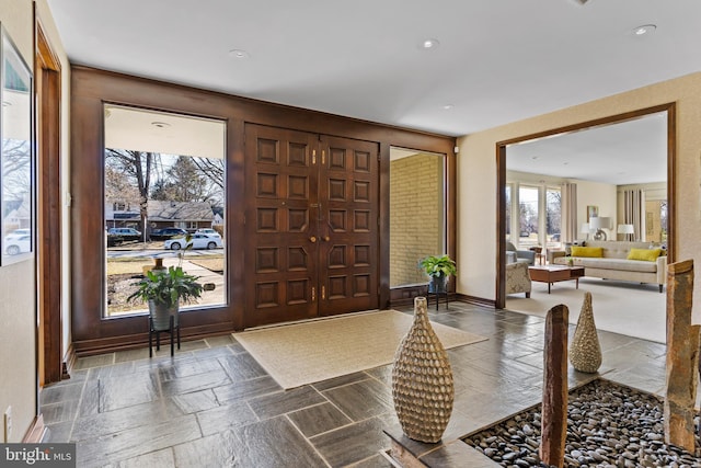 foyer featuring baseboards and stone tile floors