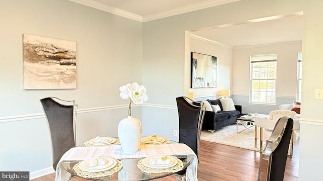 dining room featuring ornamental molding and wood finished floors