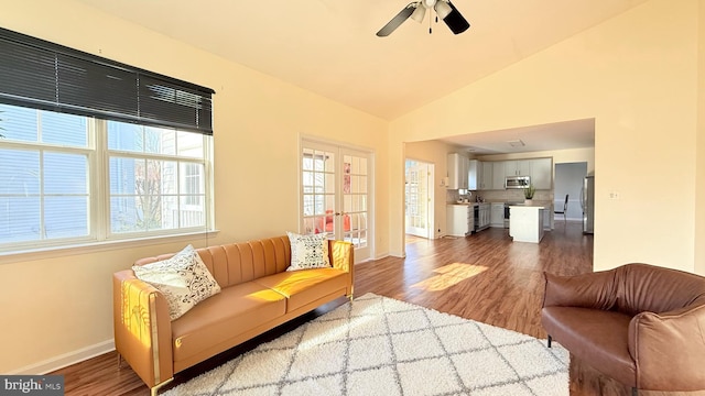 living room featuring baseboards, lofted ceiling, wood finished floors, and french doors