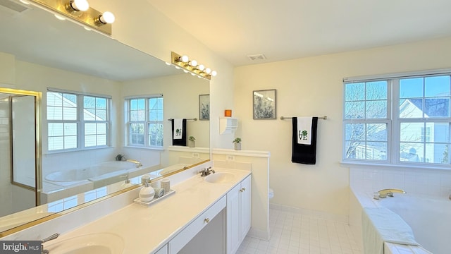 bathroom featuring double vanity, visible vents, a garden tub, and a sink