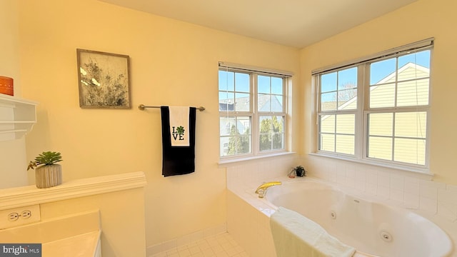 bathroom with a tub with jets and tile patterned flooring