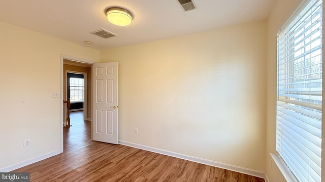 unfurnished room featuring visible vents, baseboards, and light wood-style floors