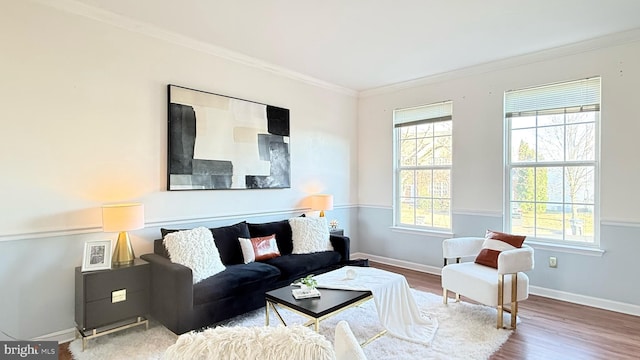 living area with crown molding, baseboards, and wood finished floors