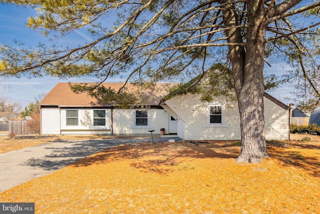 view of front of property with aphalt driveway and fence