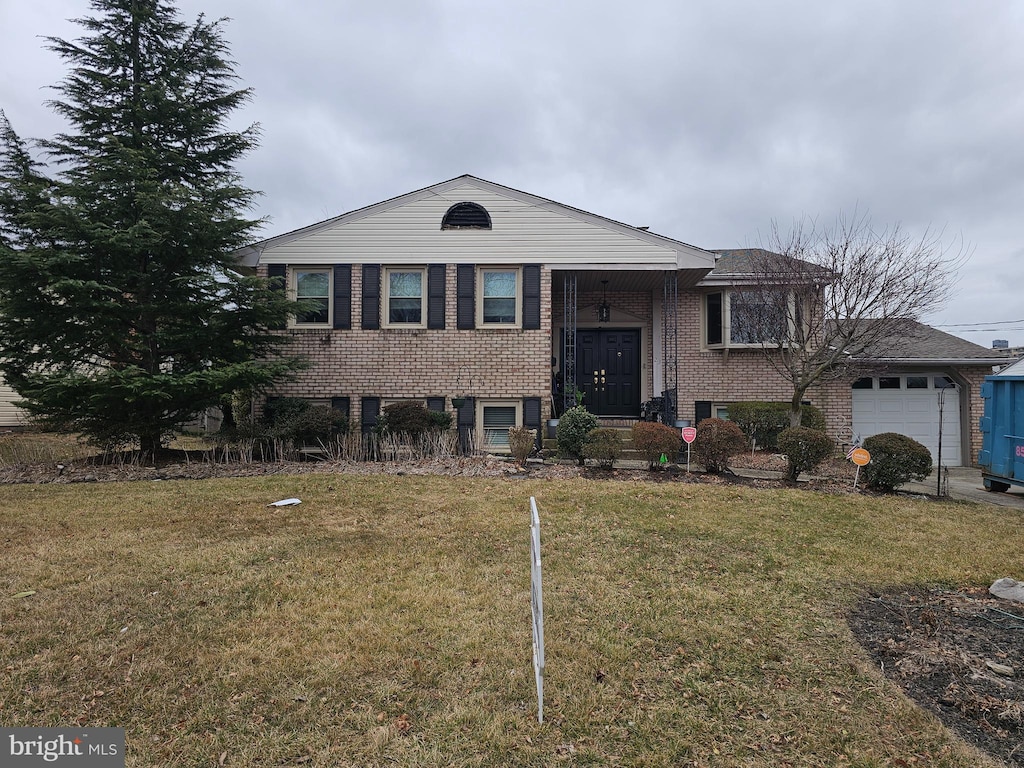 view of front of home with a front lawn, brick siding, and an attached garage