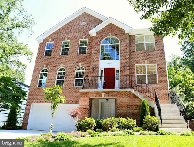 view of front of property with a garage, driveway, stairs, and brick siding