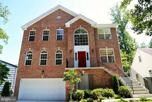 view of front of property with concrete driveway, brick siding, stairway, and an attached garage