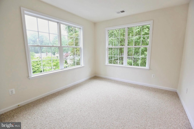 carpeted empty room with visible vents and baseboards