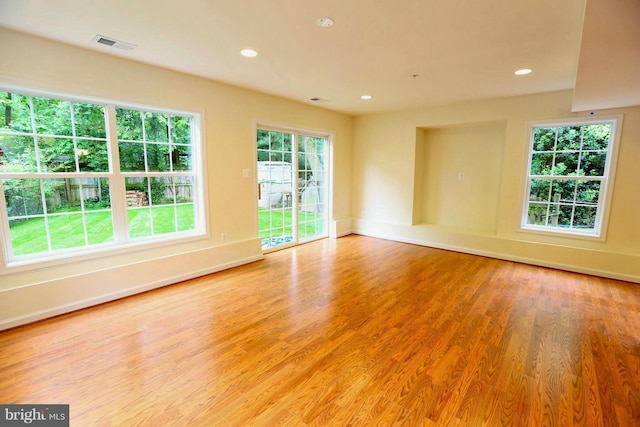 empty room featuring light wood-type flooring, visible vents, and recessed lighting