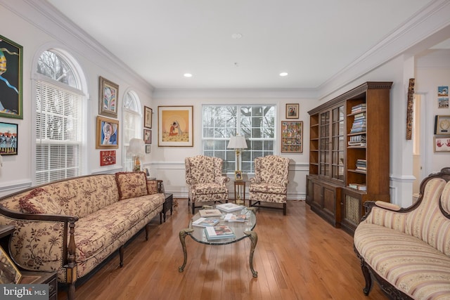 sitting room with recessed lighting, wood finished floors, a wealth of natural light, and crown molding