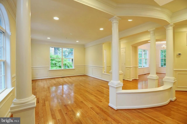 interior space with decorative columns, a wealth of natural light, and wood finished floors