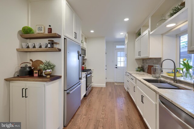 30 N Marshall St, Lancaster, PA 17602 - kitchen with a sink, open shelves, light wood-style flooring, stainless steel appliances, and white cabinets