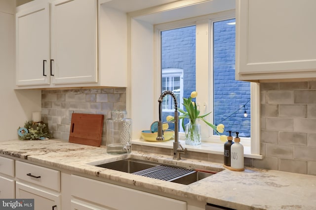 30 N Marshall St, Lancaster, PA 17602 - kitchen featuring white cabinets, a sink, tasteful backsplash, and light stone counters